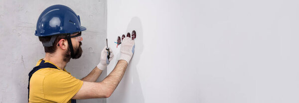 electrician in helmet installs sockets