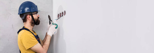electrician in helmet installs sockets