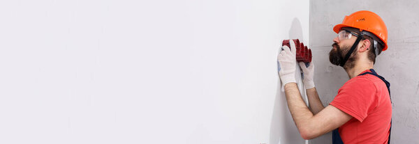 electrician in helmet installs sockets