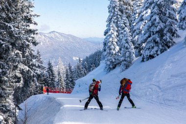 Sırt çantalı kayakçılar Bavyera Alplerinde dar yamaçlara iniyorlar.