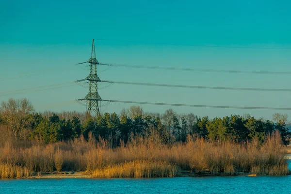 Réseau Électrique Atteignant Forêt Par Lac Bleu Décor Éclairé Par Images De Stock Libres De Droits