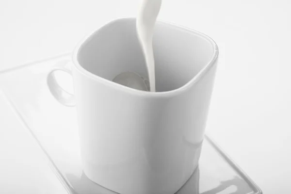 Chorro de leche sobre taza blanca — Fotografia de Stock