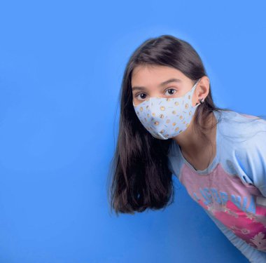 Siyah maskeli komik bir kız. Coronavirus mavisi. Komik bir ifade. Covid-19. Panorama arka planı. Kes şunu-19.