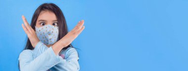 Siyah maskeli komik bir kız. Coronavirus mavisi. Komik bir ifade. Covid-19. Panorama arka planı. Kes şunu-19.