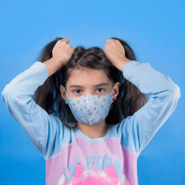 Siyah maskeli komik bir kız. Coronavirus mavisi. Komik bir ifade. Covid-19. Panorama arka planı. Kes şunu-19.