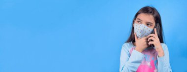 Mavi arka planda cep telefonu olan genç bir kadın.