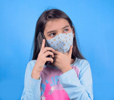 girl with mobile phone and face on blue background