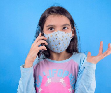 Siyah maskeli komik bir kız. Coronavirus mavisi. Komik bir ifade. Covid-19. Panorama arka planı. Kes şunu-19.