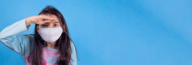 Siyah maskeli komik bir kız. Coronavirus mavisi. Komik bir ifade. Covid-19. Panorama arka planı. Kes şunu-19.