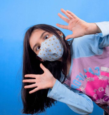 Siyah maskeli komik bir kız. Coronavirus mavisi. Komik bir ifade. Covid-19. Panorama arka planı. Kes şunu-19.