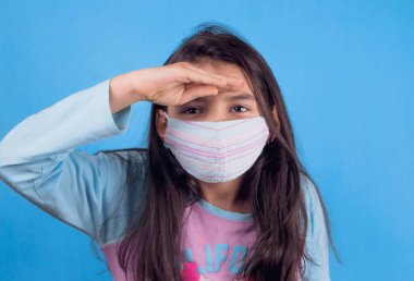 Siyah maskeli komik bir kız. Coronavirus mavisi. Komik bir ifade. Covid-19. Panorama arka planı. Kes şunu-19.