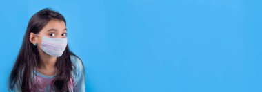 Siyah maskeli komik bir kız. Coronavirus mavisi. Komik bir ifade. Covid-19. Panorama arka planı. Kes şunu-19.