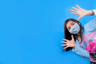 Siyah maskeli komik bir kız. Coronavirus mavisi. Komik bir ifade. Covid-19. Panorama arka planı. Kes şunu-19.