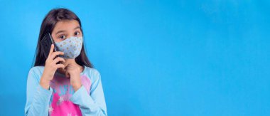 Siyah maskeli komik bir kız. Coronavirus mavisi. Komik bir ifade. Covid-19. Panorama arka planı. Kes şunu-19.