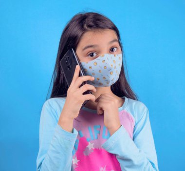 Siyah maskeli komik bir kız. Coronavirus mavisi. Komik bir ifade. Covid-19. Panorama arka planı. Kes şunu-19.