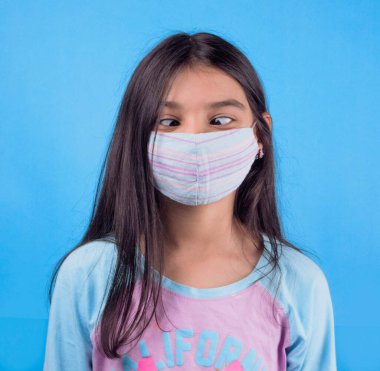 Siyah maskeli komik bir kız. Coronavirus mavisi. Komik bir ifade. Covid-19. Panorama arka planı. Kes şunu-19.