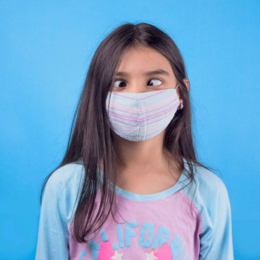 Siyah maskeli komik bir kız. Coronavirus mavisi. Komik bir ifade. Covid-19. Panorama arka planı. Kes şunu-19.