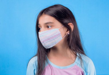 Siyah maskeli komik bir kız. Coronavirus mavisi. Komik bir ifade. Covid-19. Panorama arka planı. Kes şunu-19.