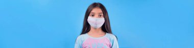 Siyah maskeli komik bir kız. Coronavirus mavisi. Komik bir ifade. Covid-19. Panorama arka planı. Kes şunu-19.