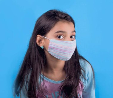 Siyah maskeli komik bir kız. Coronavirus mavisi. Komik bir ifade. Covid-19. Panorama arka planı. Kes şunu-19.