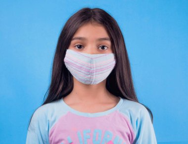 Siyah maskeli komik bir kız. Coronavirus mavisi. Komik bir ifade. Covid-19. Panorama arka planı. Kes şunu-19.