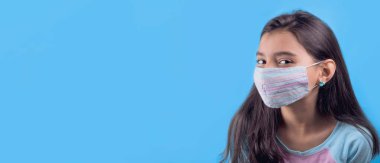 Siyah maskeli komik bir kız. Coronavirus mavisi. Komik bir ifade. Covid-19. Panorama arka planı. Kes şunu-19.