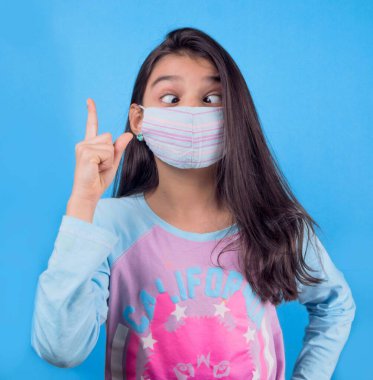 Siyah maskeli komik bir kız. Coronavirus mavisi. Komik bir ifade. Covid-19. Panorama arka planı. Kes şunu-19.