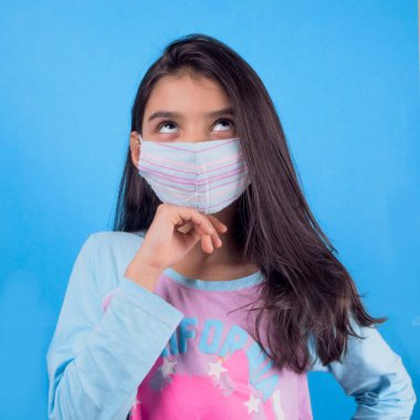 Siyah maskeli komik bir kız. Coronavirus mavisi. Komik bir ifade. Covid-19. Panorama arka planı. Kes şunu-19.