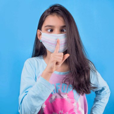 Siyah maskeli komik bir kız. Coronavirus mavisi. Komik bir ifade. Covid-19. Panorama arka planı. Kes şunu-19.