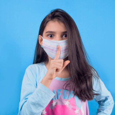 Siyah maskeli komik bir kız. Coronavirus mavisi. Komik bir ifade. Covid-19. Panorama arka planı. Kes şunu-19.