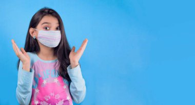 Siyah maskeli komik bir kız. Coronavirus mavisi. Komik bir ifade. Covid-19. Panorama arka planı. Kes şunu-19.