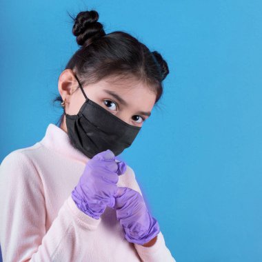 Siyah maskeli komik bir kız. Coronavirus mavisi. Komik bir ifade. Covid-19. Panorama arka planı. Kes şunu-19.