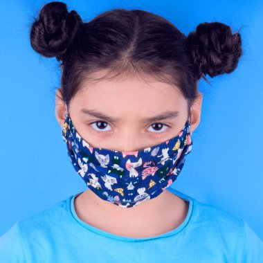 Siyah maskeli komik bir kız. Coronavirus mavisi. Komik bir ifade. Covid-19. Panorama arka planı. Kes şunu-19.