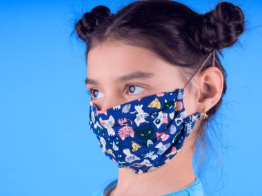 Siyah maskeli komik bir kız. Coronavirus mavisi. Komik bir ifade. Covid-19. Panorama arka planı. Kes şunu-19.