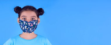 Siyah maskeli komik bir kız. Coronavirus mavisi. Komik bir ifade. Covid-19. Panorama arka planı. Kes şunu-19.