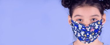 Siyah maskeli komik bir kız. Coronavirus mavisi. Komik bir ifade. Covid-19. Panorama arka planı. Kes şunu-19.