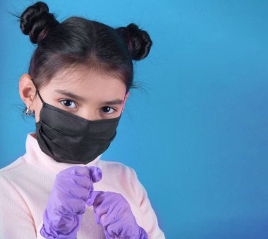 Koruyucu eldiven ve maske takmış, elleri çapraz duran güzel bir kadının portresi.,