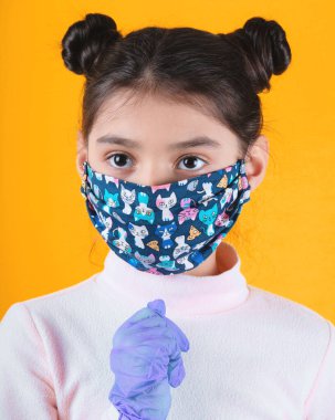 Güzel kız koruyucu yüz maskesi takıyor, yukarı bakıyor.