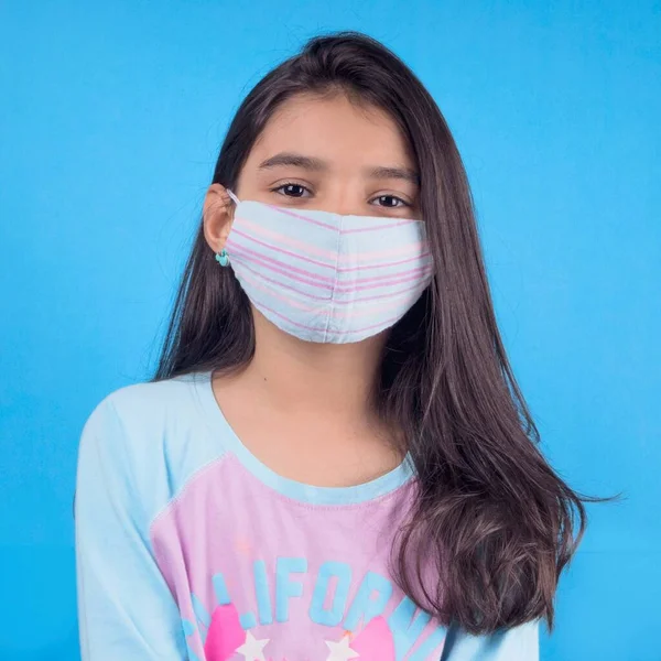 Siyah maskeli komik bir kız. Coronavirus mavisi. Komik bir ifade. Covid-19. Panorama arka planı. Kes şunu-19.