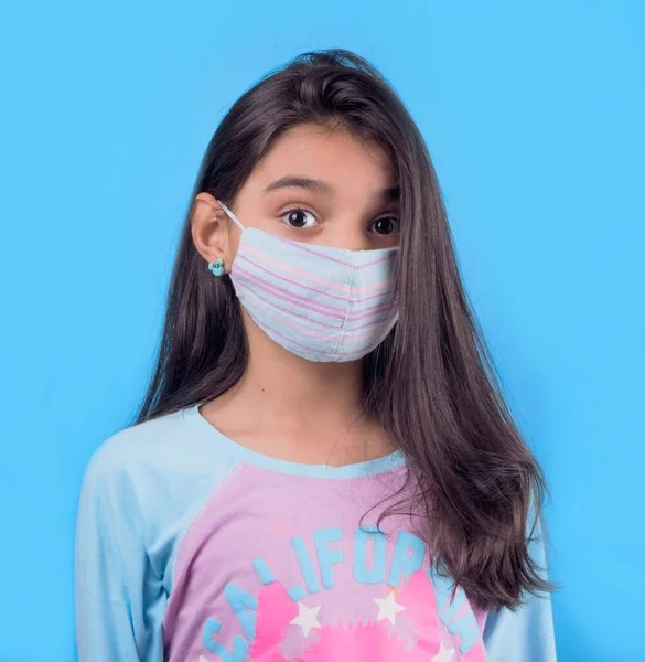 Siyah maskeli komik bir kız. Coronavirus mavisi. Komik bir ifade. Covid-19. Panorama arka planı. Kes şunu-19.