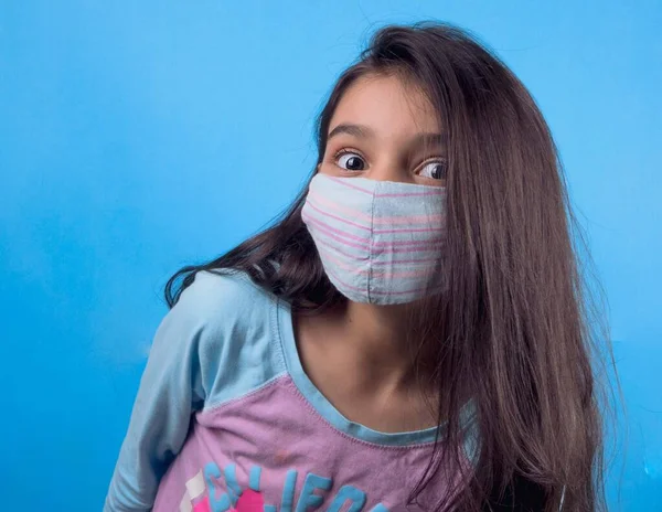 Siyah maskeli komik bir kız. Coronavirus mavisi. Komik bir ifade. Covid-19. Panorama arka planı. Kes şunu-19.