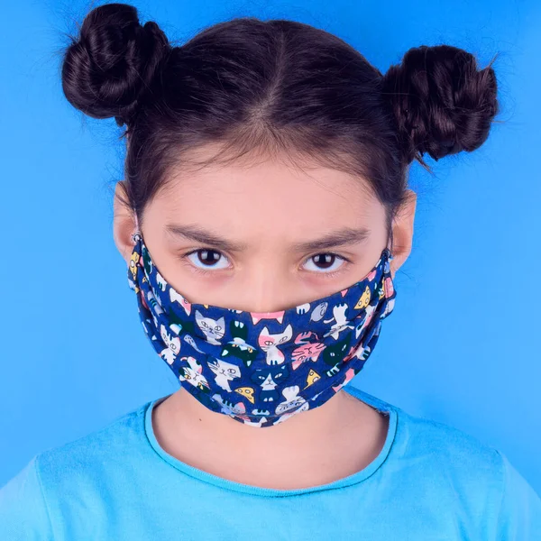 Siyah maskeli komik bir kız. Coronavirus mavisi. Komik bir ifade. Covid-19. Panorama arka planı. Kes şunu-19.