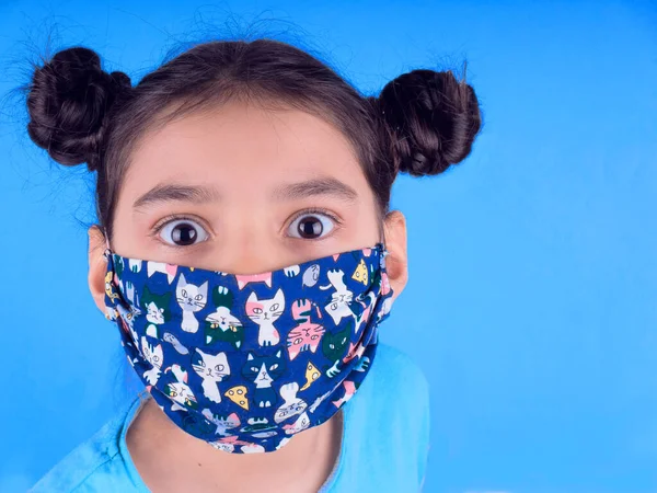 Siyah maskeli komik bir kız. Coronavirus mavisi. Komik bir ifade. Covid-19. Panorama arka planı. Kes şunu-19.