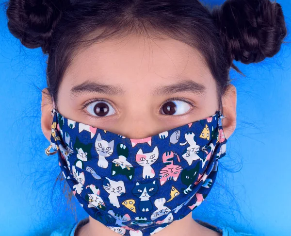 Siyah maskeli komik bir kız. Coronavirus mavisi. Komik bir ifade. Covid-19. Panorama arka planı. Kes şunu-19.