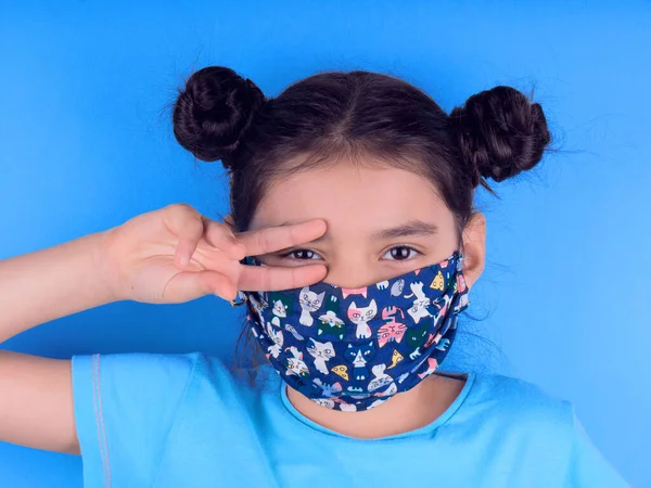 Siyah maskeli komik bir kız. Coronavirus mavisi. Komik bir ifade. Covid-19. Panorama arka planı. Kes şunu-19.