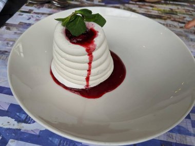 Kırmızı böğürtlenli krema ve kremalı pasta. Beyaz tabakta tatlı tatlı