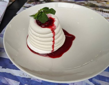 Kırmızı böğürtlenli krema ve kremalı pasta. Beyaz tabakta tatlı tatlı