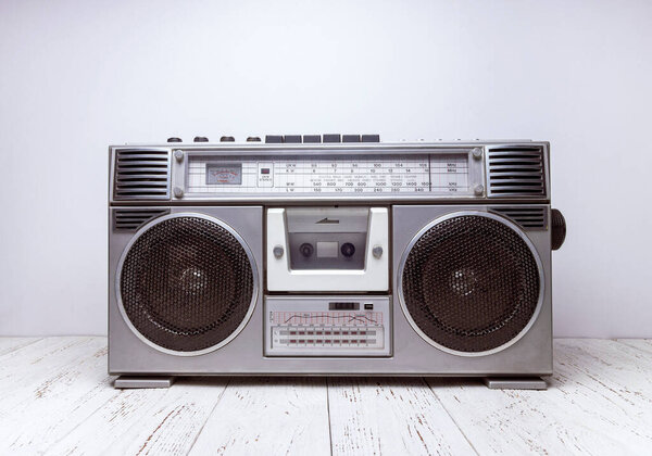 Cassette retro tape recorder stands on a table in front of a white background