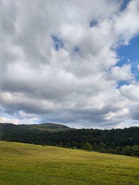Bulutlu gökyüzünde tarlası olan güzel bir manzara.