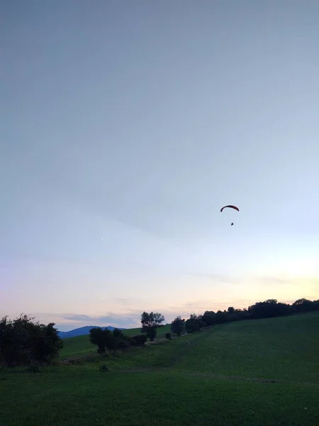 自然を背景に空を飛ぶパラグライダー — ストック写真